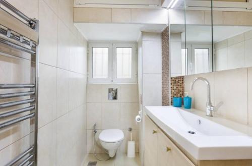 uma casa de banho branca com um lavatório e um WC em Eli Greko Apartament em Chania Town