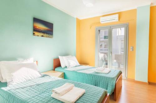 - une chambre avec 2 lits et des serviettes dans l'établissement Eli Greko Apartament, à La Canée