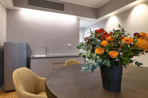 a vase of flowers sitting on top of a table at PRESTIGE BOUTIQUE APARTHOTEL -Piazza Duomo in Milan
