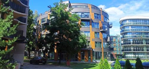 a tall building with a tree in front of it at Chocolate Apart in Druskininkai