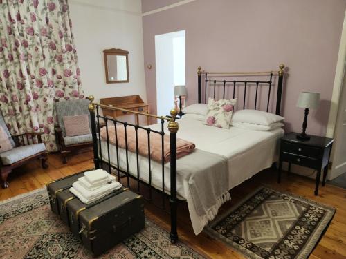 a bedroom with a bed and a suitcase on the floor at Die Dorpshuis Graaff Reinet in Graaff-Reinet