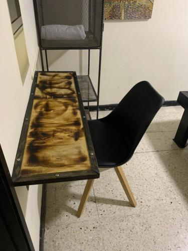 a black chair sitting next to a wooden table at Hotel Bisou in Cali