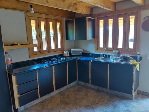 een keuken met blauwe kasten en een wastafel bij Cabaña Rústica in El Limoncito
