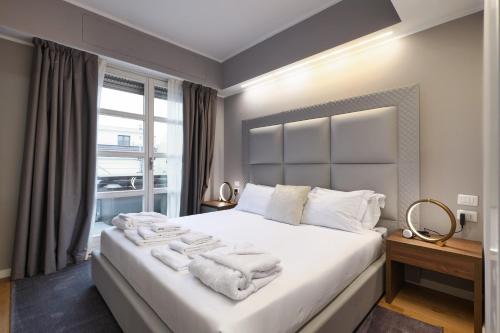 a bedroom with a large white bed with towels on it at PRESTIGE BOUTIQUE APARTHOTEL -Piazza Duomo in Milan