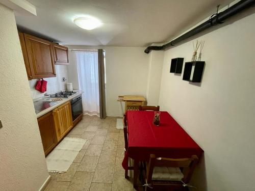 a small kitchen with a red table and chairs at BOUQUE GEORGEOLINE in Rhêmes-Notre-Dame