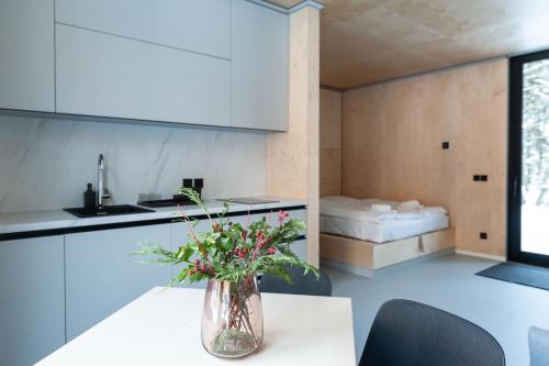 a kitchen with a table with a vase of flowers on it at Mountain Cabin by the river - Base Camp Medvědín in Špindlerův Mlýn
