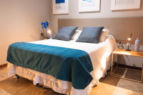 a bedroom with a large bed with blue pillows at Casa da Lua Pousada in Alto Paraíso de Goiás