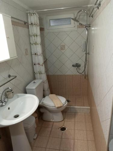 a bathroom with a toilet and a sink at Central Fountain in Asprovalta