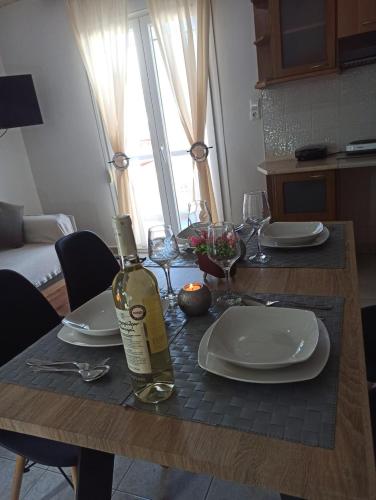 a dining room table with a bottle of wine on it at Central Fountain in Asprovalta