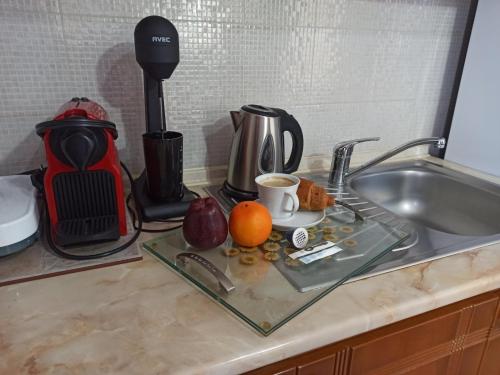 a kitchen counter with a sink with a coffee maker and fruits at Central Fountain in Asprovalta