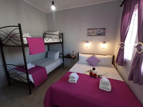 a bedroom with two bunk beds with purple sheets at Central Fountain in Asprovalta