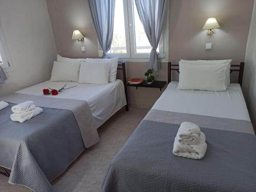 a hotel room with two beds with towels on them at Central Fountain in Asprovalta