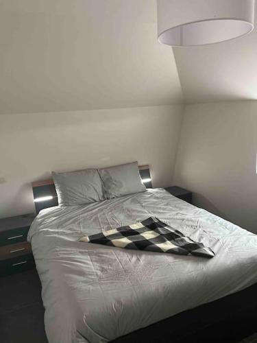 a bed with a black and white checkered blanket on it at A la Vida in Bruges