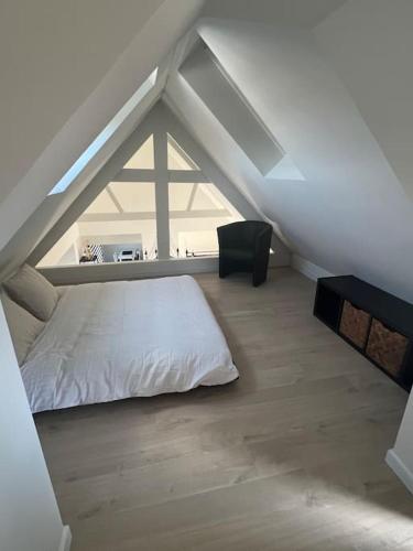 sypialnia z białym łóżkiem na poddaszu w obiekcie A la Vida w Brugii