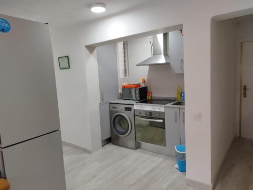 a kitchen with a washing machine and a stove at Habitación individual en Pozuelo de Alarcón in Pozuelo de Alarcón