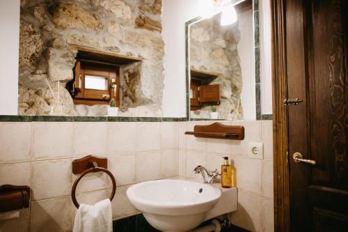 a bathroom with a sink and a mirror at Apartamentos Rurales La Casina del Fontan in Valle de Lago