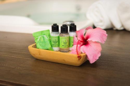 a wooden tray with three bottles of soap and a flower at Casa da Lua Pousada in Alto Paraíso de Goiás