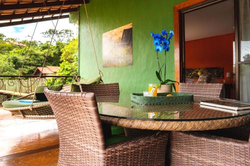 a dining room with a table and wicker chairs at Casa da Lua Pousada in Alto Paraíso de Goiás