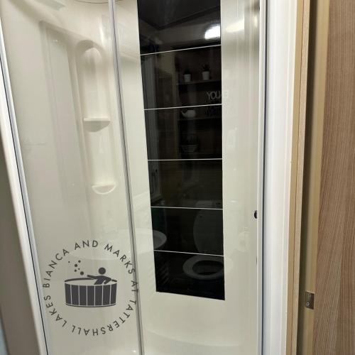 a glass door with a sign that says kitchen and milk at Bianca and marks 8 berth Caravan with Hot tub in Tattershall