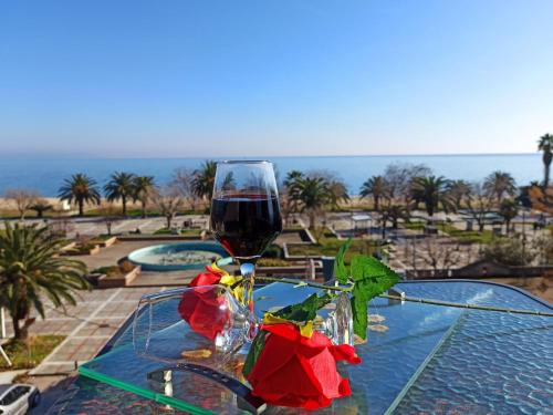 a glass of wine sitting on a glass table at Central Fountain in Asprovalta