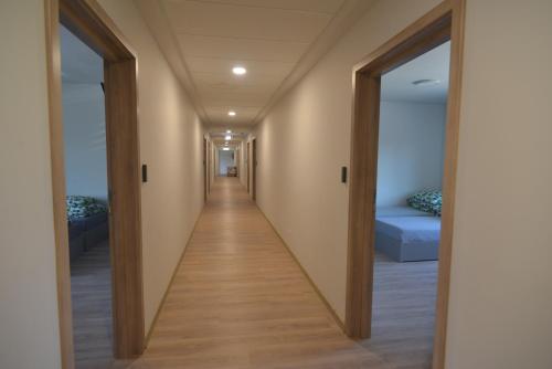 a corridor of a hospital hallway with two doors at Noclegi URAN in Sufczyn