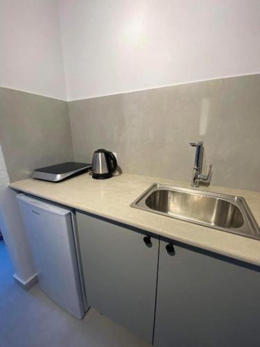 a kitchen counter with a sink and a kettle on it at Ikaros Studios in Faliraki