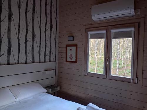 a bedroom with a bed and a window at Cabanas da Ulla in Touro