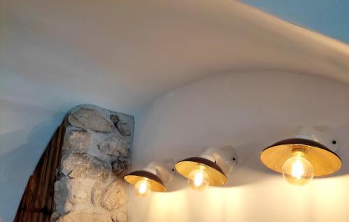 a row of lights on a wall with a stone wall at Künstlerhaus Weissgerbergütl in Marquartstein