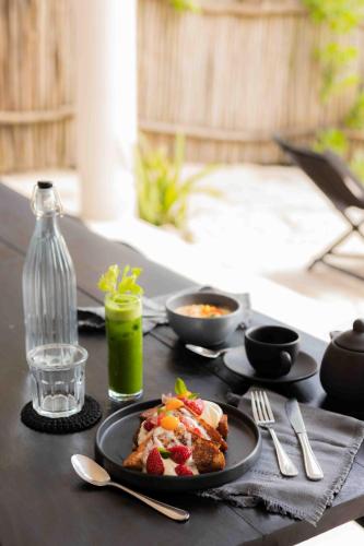 a table with a plate of food and a drink at NEST Tulum in Tulum