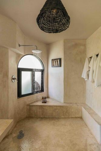 a large bathroom with a tub and a window at NEST Tulum in Tulum