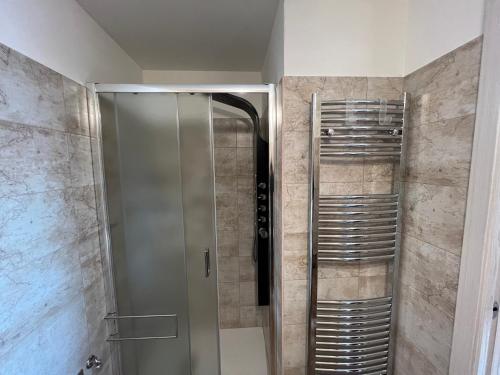 una doccia con porta in vetro in bagno di Appartamento Sara a Commezzadura