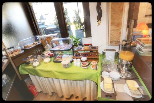 una mesa con un mantel verde con comida. en Pension Sonnenheim, en Winterberg