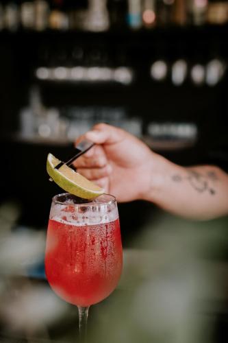 a person holding a cell phone next to a drink at NEST Tulum in Tulum