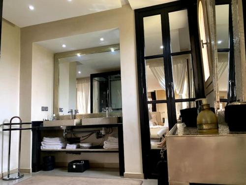 a bathroom with a sink and a large mirror at Villa Coty Palmeraie in Marrakesh