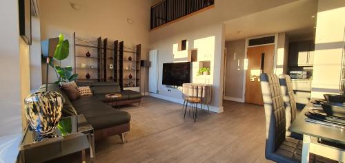 a living room with a couch and a table at The Beautiful Bankmore Penthouse in Belfast