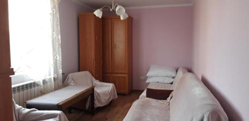 um quarto com duas camas e um banco em Noclegi u Janinki em Ostrowiec Świetokrzyski