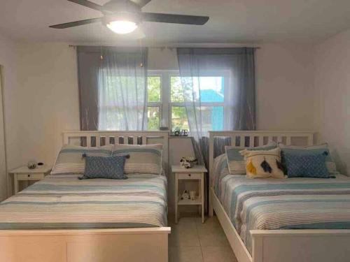 フリーポートにあるEntire Home - Relaxing Ocean View Condoのベッド2台と天井ファン付きの寝室