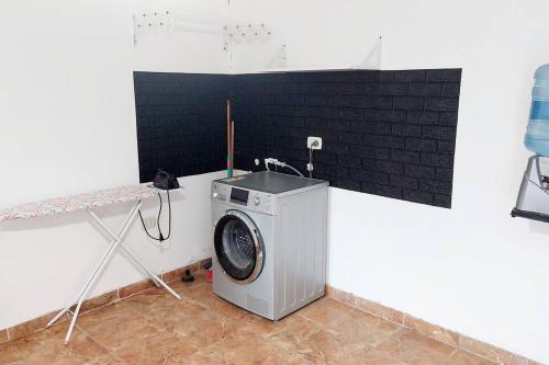 een wasmachine in een kamer met een wastafel bij Casa Familiar in La Rioja