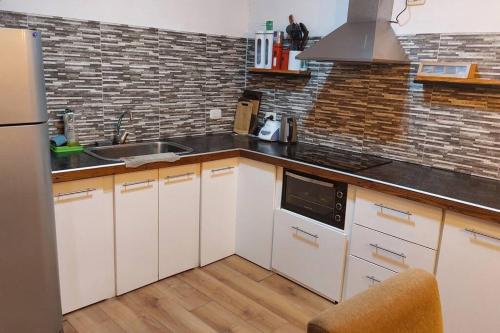 a kitchen with white cabinets and a black counter top at Casa Familiar in La Rioja