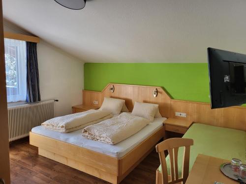 a bedroom with a bed with a green wall at Haus Ortsblick in Wagrain