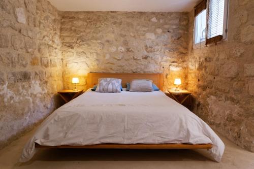 une chambre avec un lit avec deux lampes sur deux tables dans l'établissement Les Tournelles, à Courbevoie