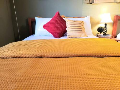 a bed with an orange blanket and pillows on it at White Sands Oasis in Alamogordo