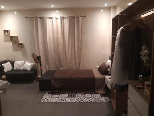 una camera con letto e divano di Résidence Edelweiss a Dakar