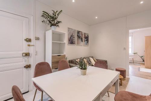 una sala da pranzo bianca con tavolo e sedie bianchi di 2 chambres, proche hyper centre a Reims