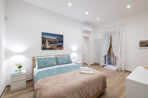 een witte slaapkamer met een groot bed in een kamer bij Adelis Case Vacanza in Napels