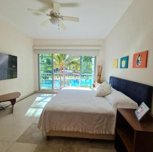 um quarto com uma cama grande e uma ventoinha de tecto em Lujoso Departamento en Acapulco con Alberca y club de Playa em Acapulco