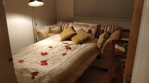 a bedroom with a bed with red flowers on it at Chandeliers 6 in Shrewsbury