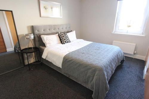 a bedroom with a large bed and a window at Spacious 2 Bed, 2 Bath apartment -The Shore, Leith in Edinburgh