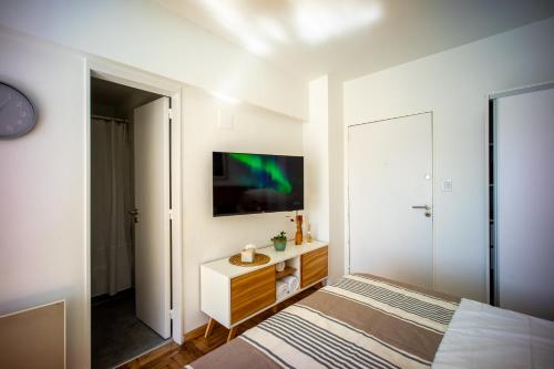 1 dormitorio con 1 cama y TV en la pared en Monoambiente en Recoleta by BA Rent a Home en Buenos Aires