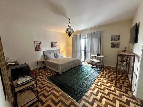 a bedroom with a bed and a television in a room at Deck Hospedaria in Cunha